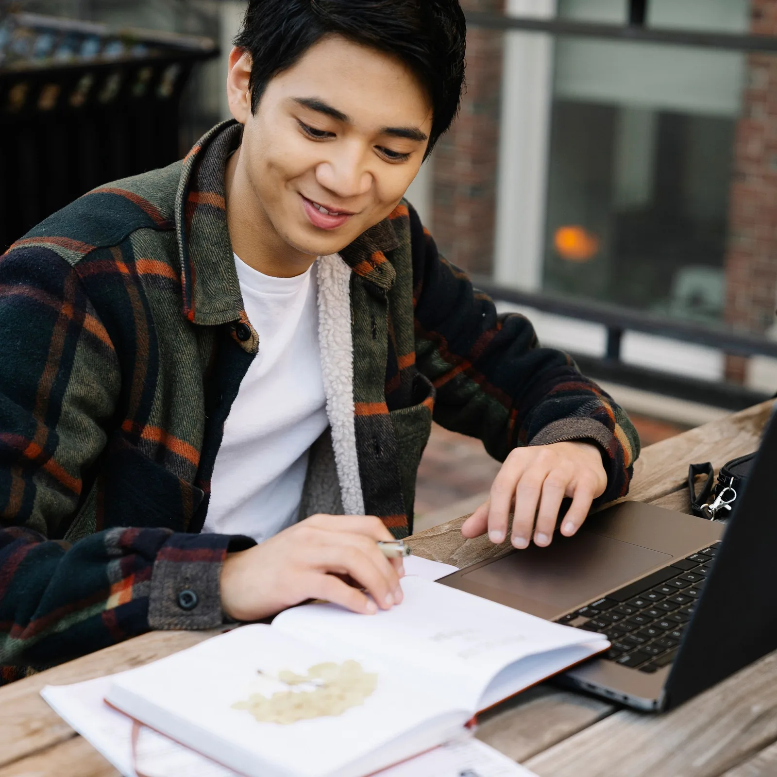 Stagiaire adulte en reconversion travaillant son dossier de formation, cahier et ordinateur portable